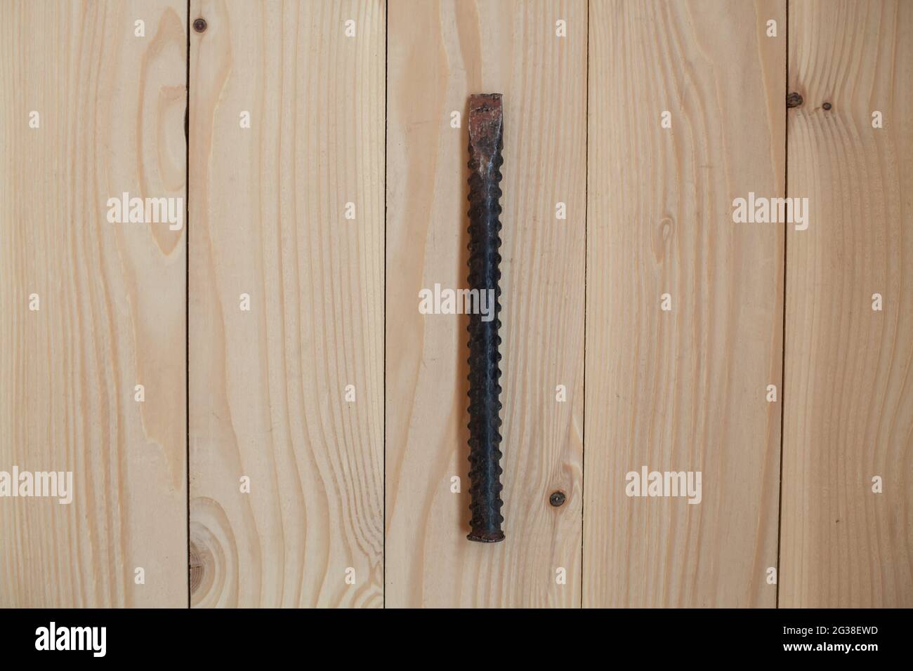 Burin de fer sur fond en bois clair. Concept de travail. Banque D'Images