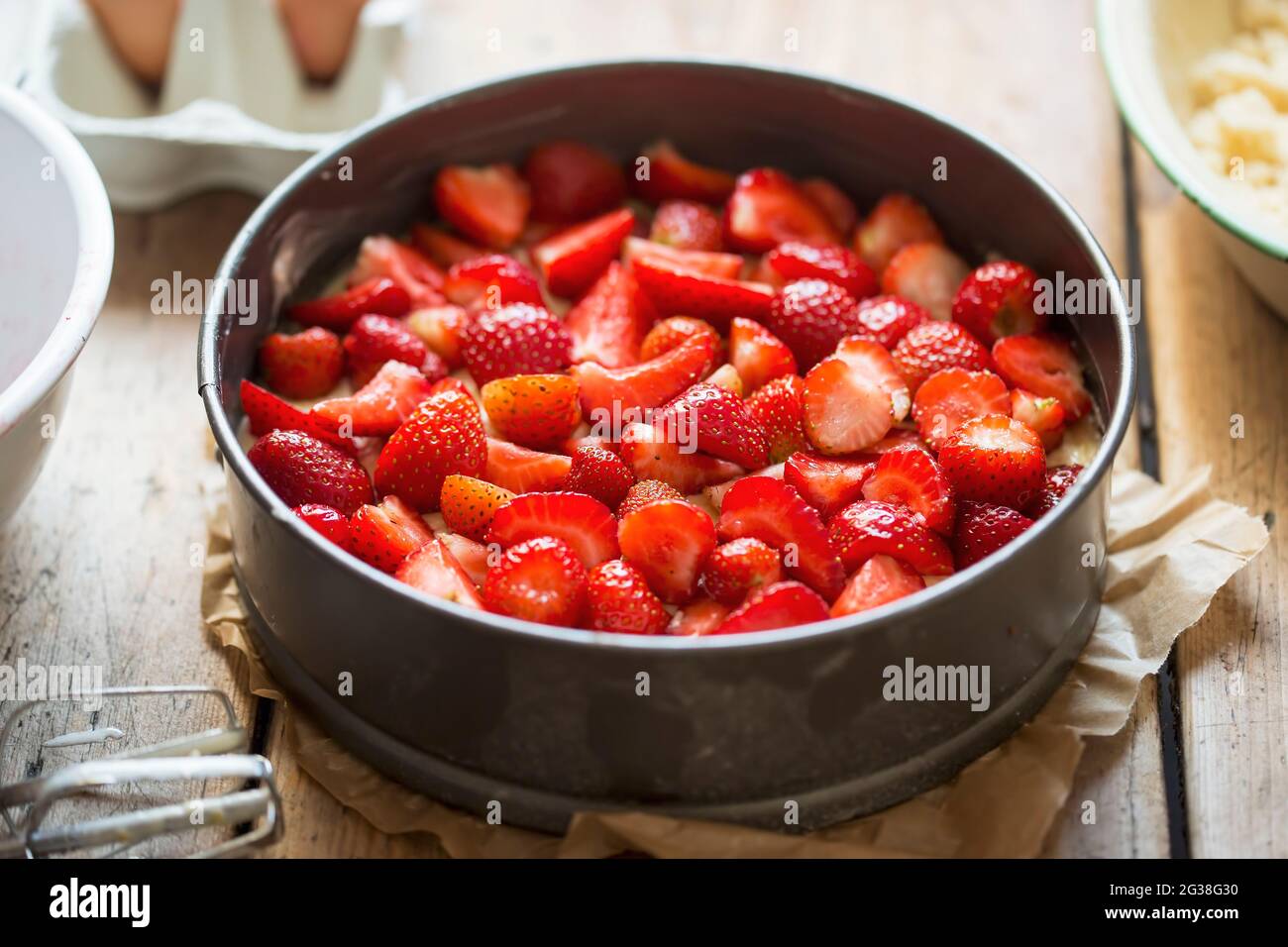 Gâteau de pâtisserie cru au yaourt prêt à cuire avec fraises et crumble Banque D'Images