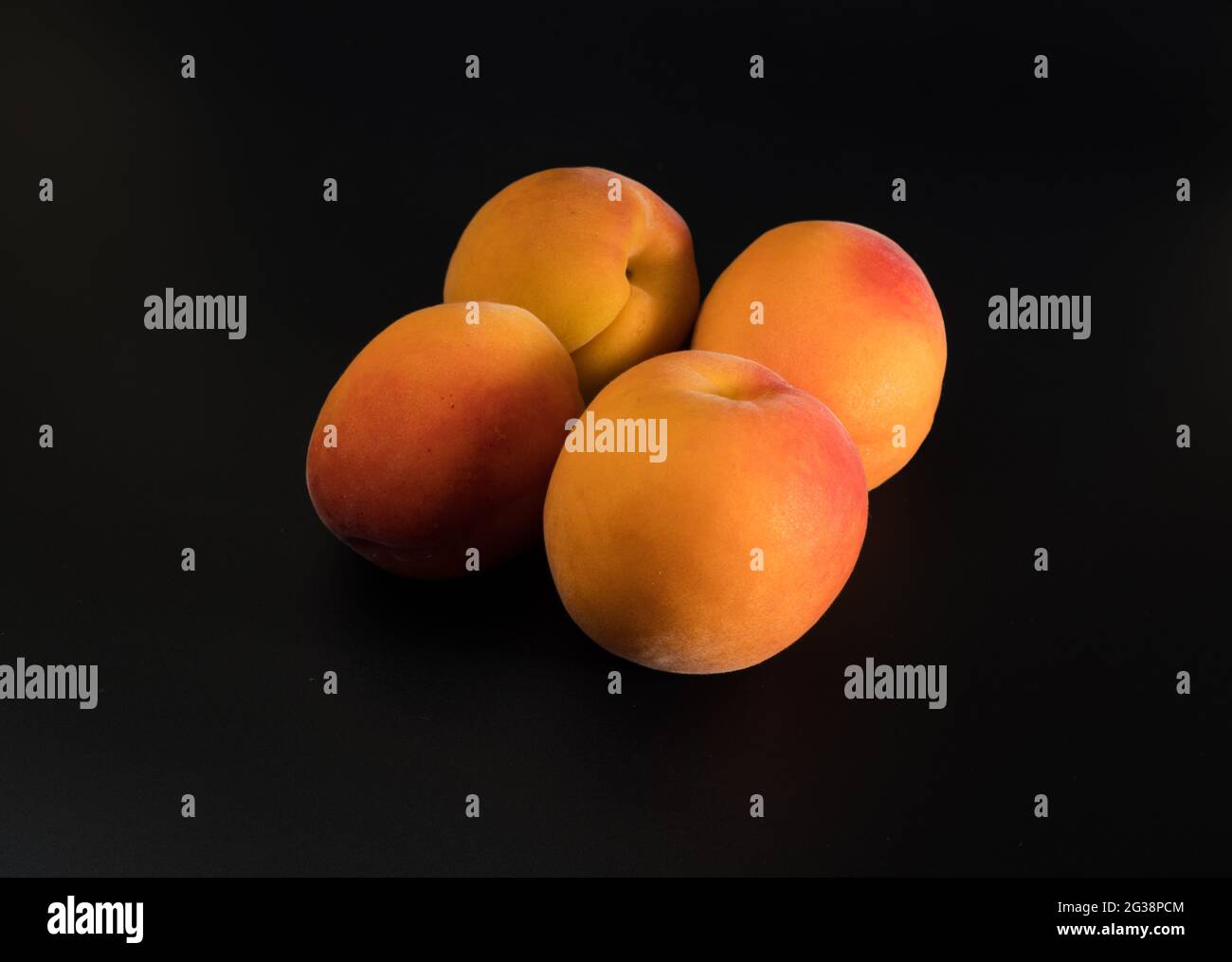 Quatre fruits mûrs d'Apricot, sur fond noir, isolés Banque D'Images