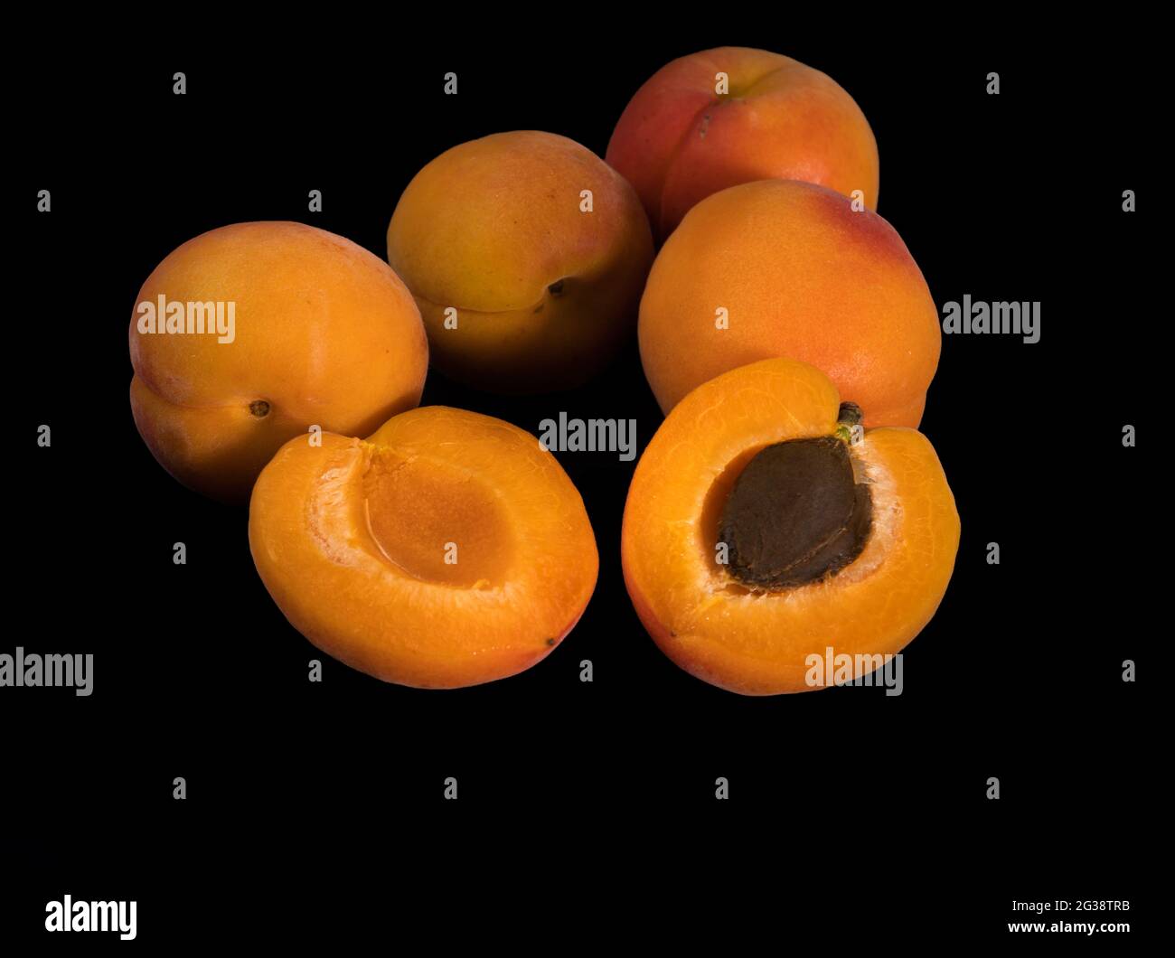 Un bouquet de fruits Apricot mûrs, entiers et en tranches, sur un fond noir en isolement Banque D'Images