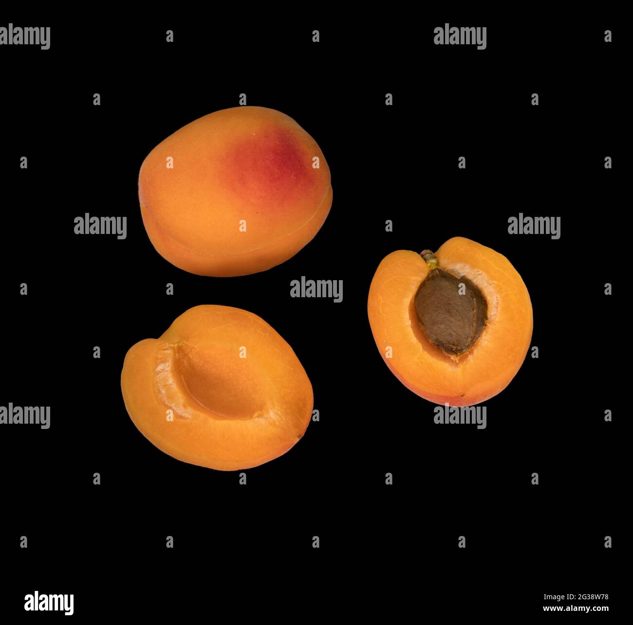 Fruits abricot mûrs, un abricot entier et deux morceaux d'abricot divisés, sur un fond noir isolé Banque D'Images