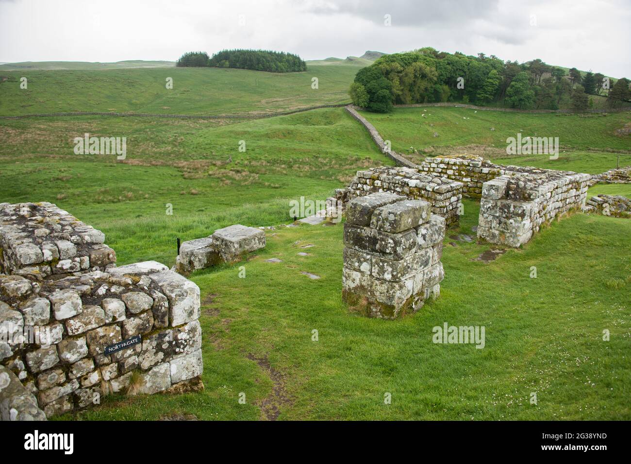 Vestiges de l'ancienne porte nord du fort romain Housesteads avec vue vers le nord-est. Longeant l'ensemble du site classé au patrimoine mondial de l'UNESCO, le chemin du mur d'Hadrien est l'un des sentiers de randonnée les plus populaires d'Angleterre. Banque D'Images