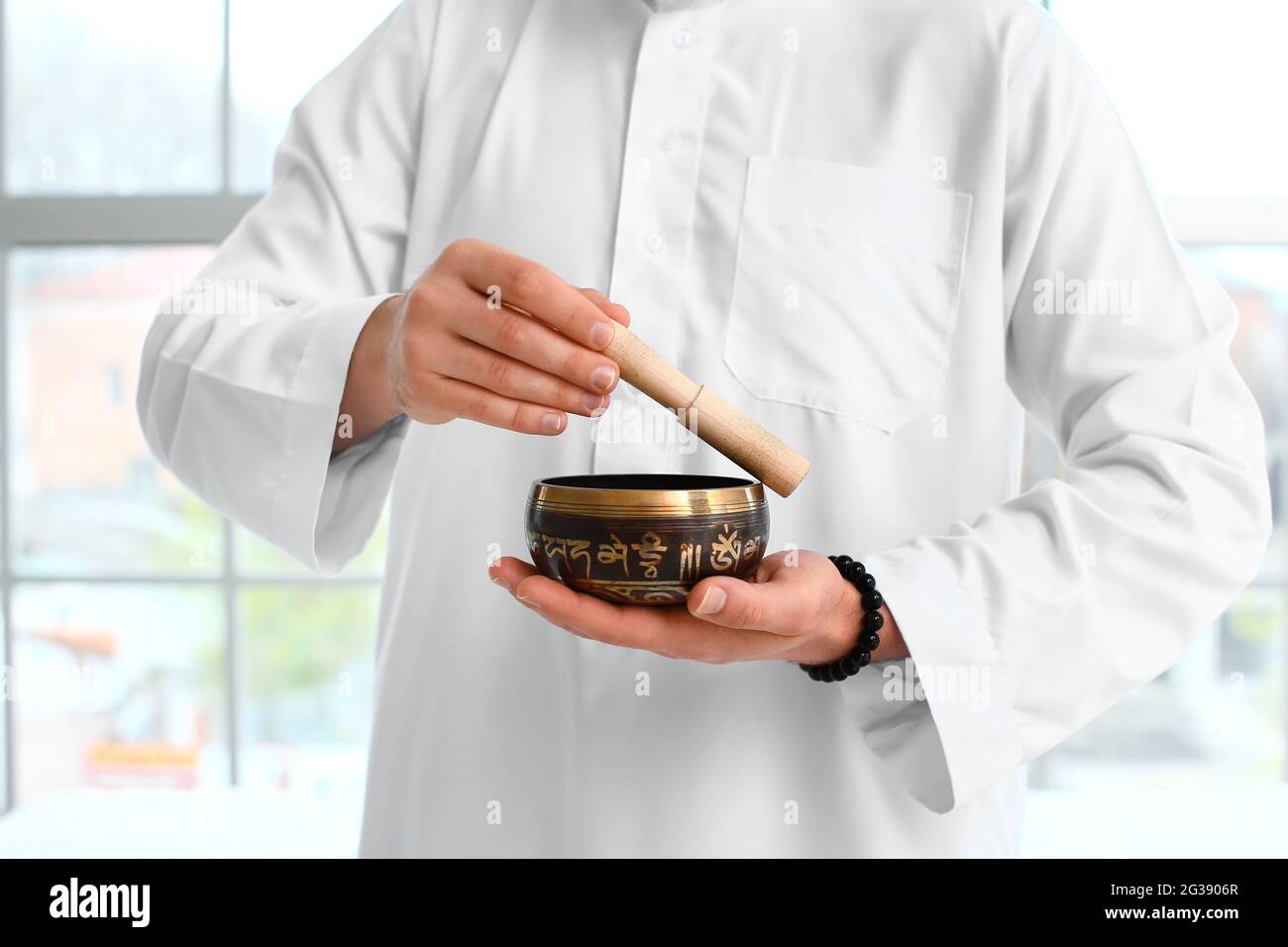 Maître Reiki utilisant un bol de chant tibétain Banque D'Images