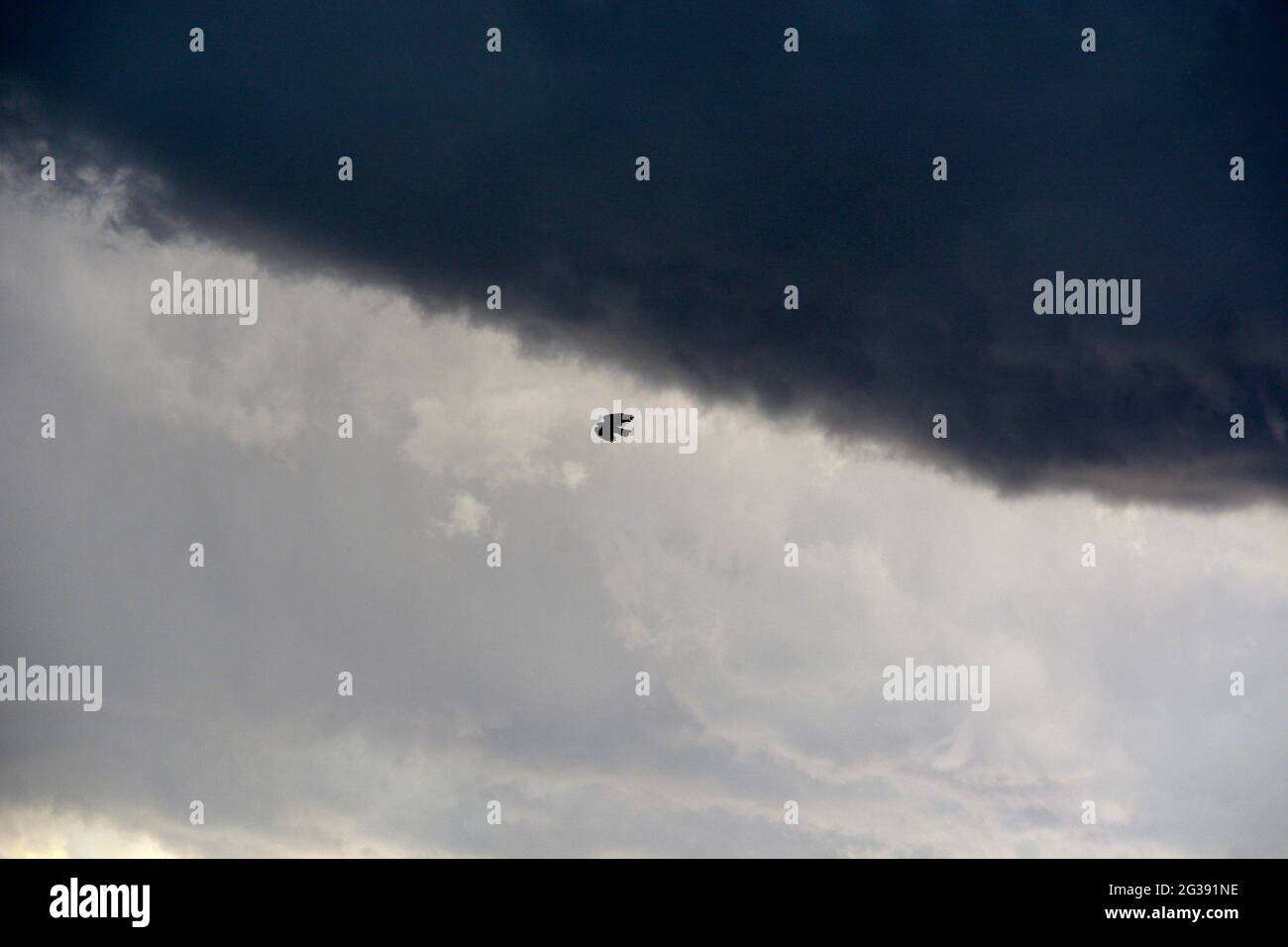 Un corbeau vole sous des nuages de pluie sombres à Santa Fe, Nouveau-Mexique. Banque D'Images