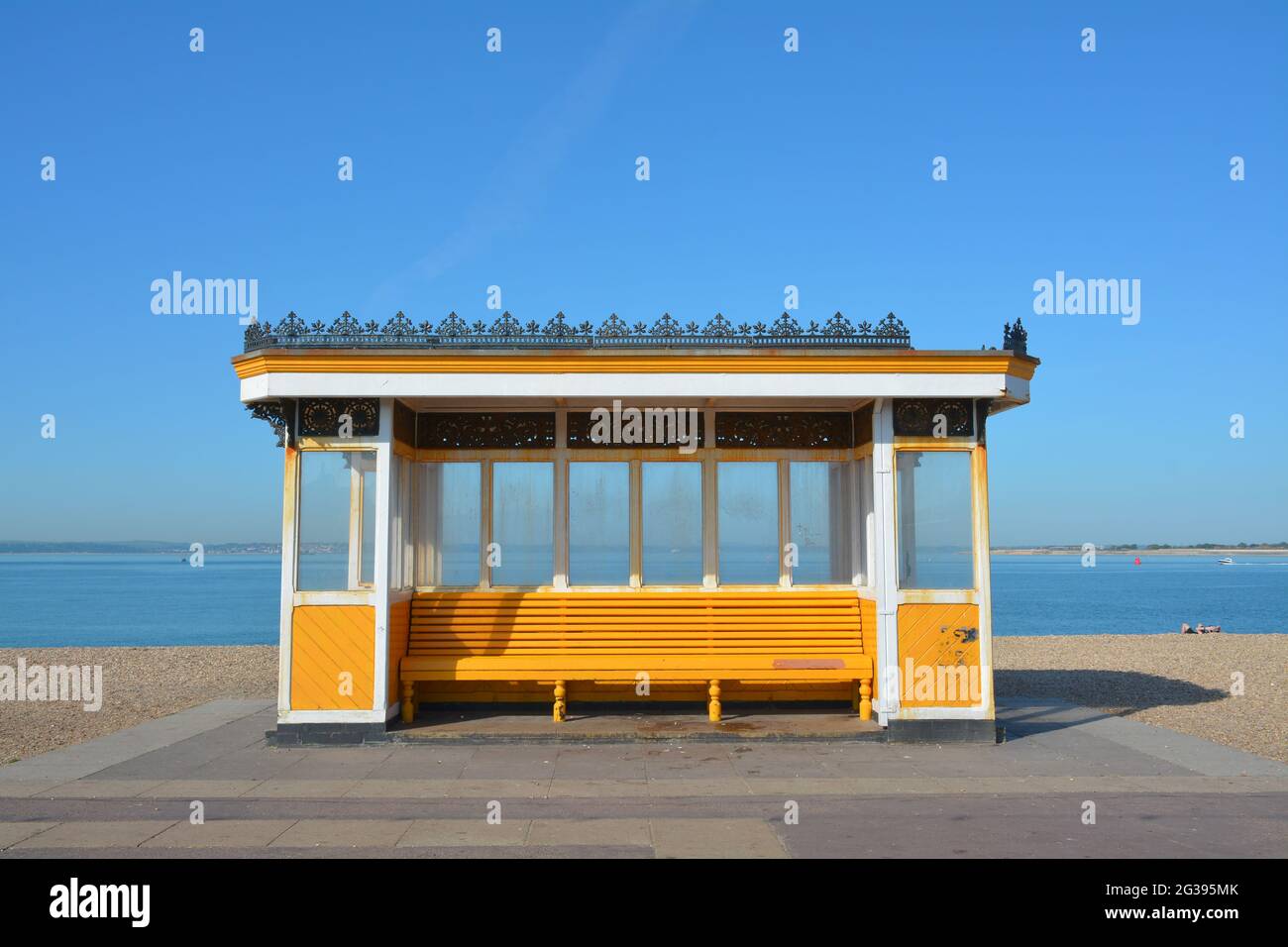 Abri aux vents jaune et blanc lumineux sur le front de mer de Southsea. Place pour s'asseoir et regarder sur le Solent à l'île de Wight Banque D'Images