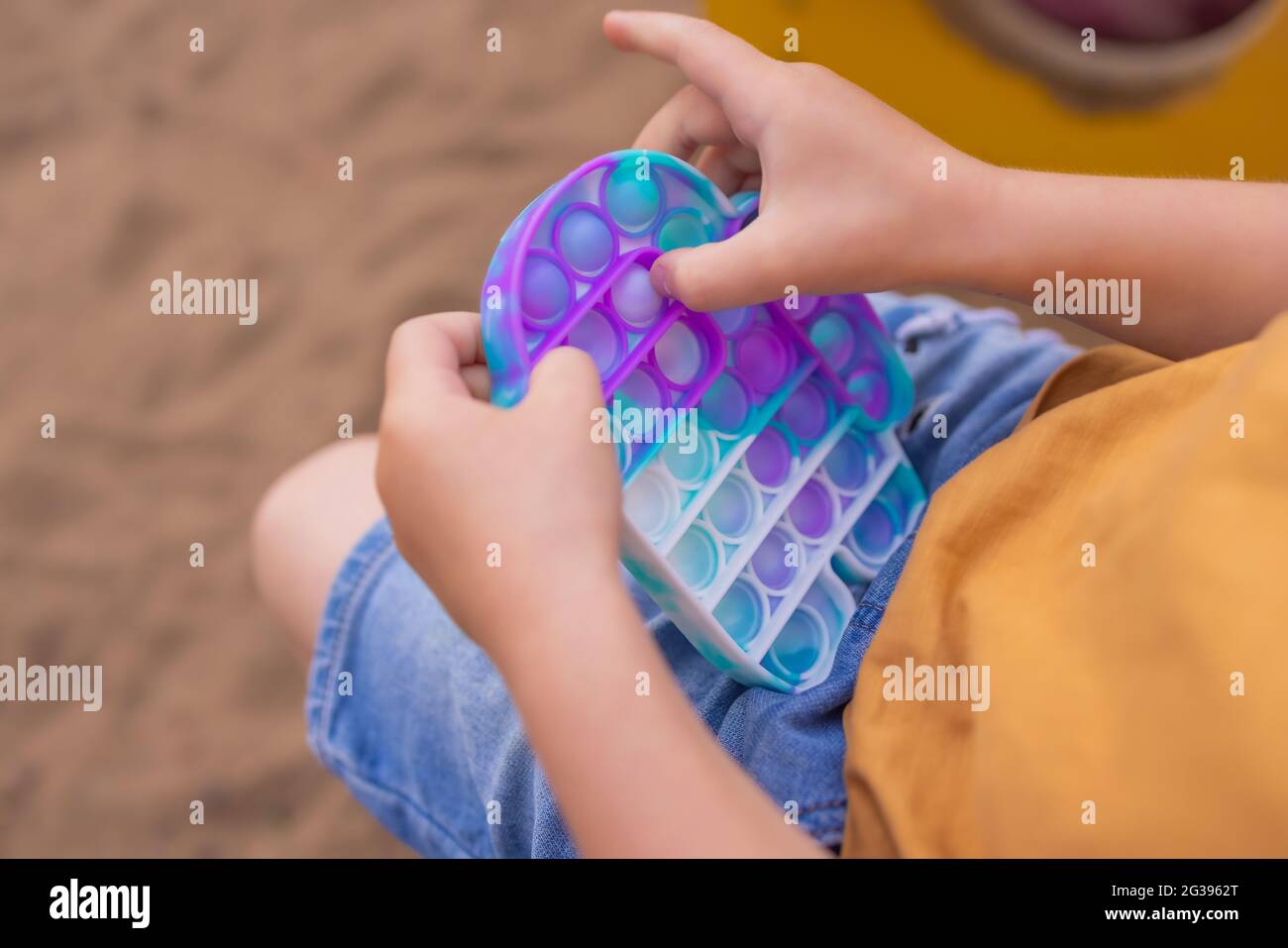 Le jouet sensoriel antistress coloré de violon pousser dans les mains de tout-petit. Jouet pop IT tendance antistress. Violon sensoriel Rainbow. Nouveau jouet en silicone tendance Banque D'Images