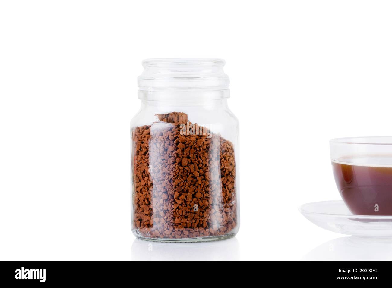 Une boisson à base de café est versée dans la tasse. Un café délicieux et  aromatique est versé dans une tasse, à côté il y a un pot de grains de café