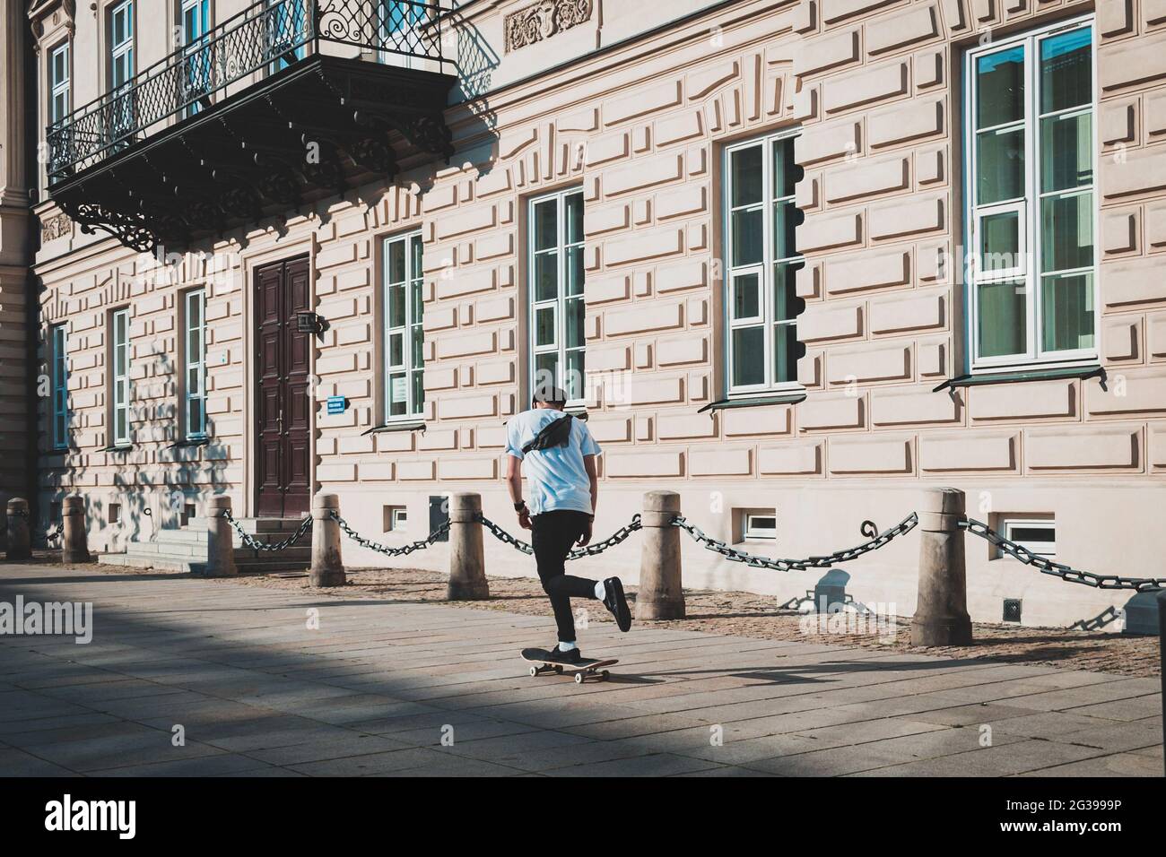 homme à cheval sur un skateboard dans des vêtements décontractés, dans les rues de la ville Banque D'Images