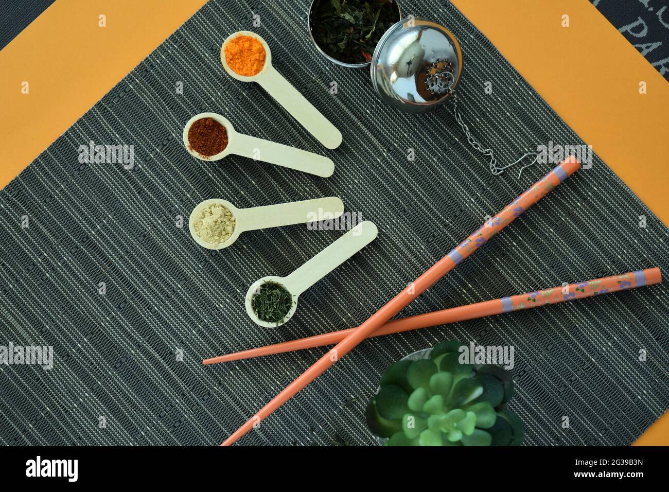 Table avec épices, arômes, baguettes, plantes et infusions asiatiques. Banque D'Images