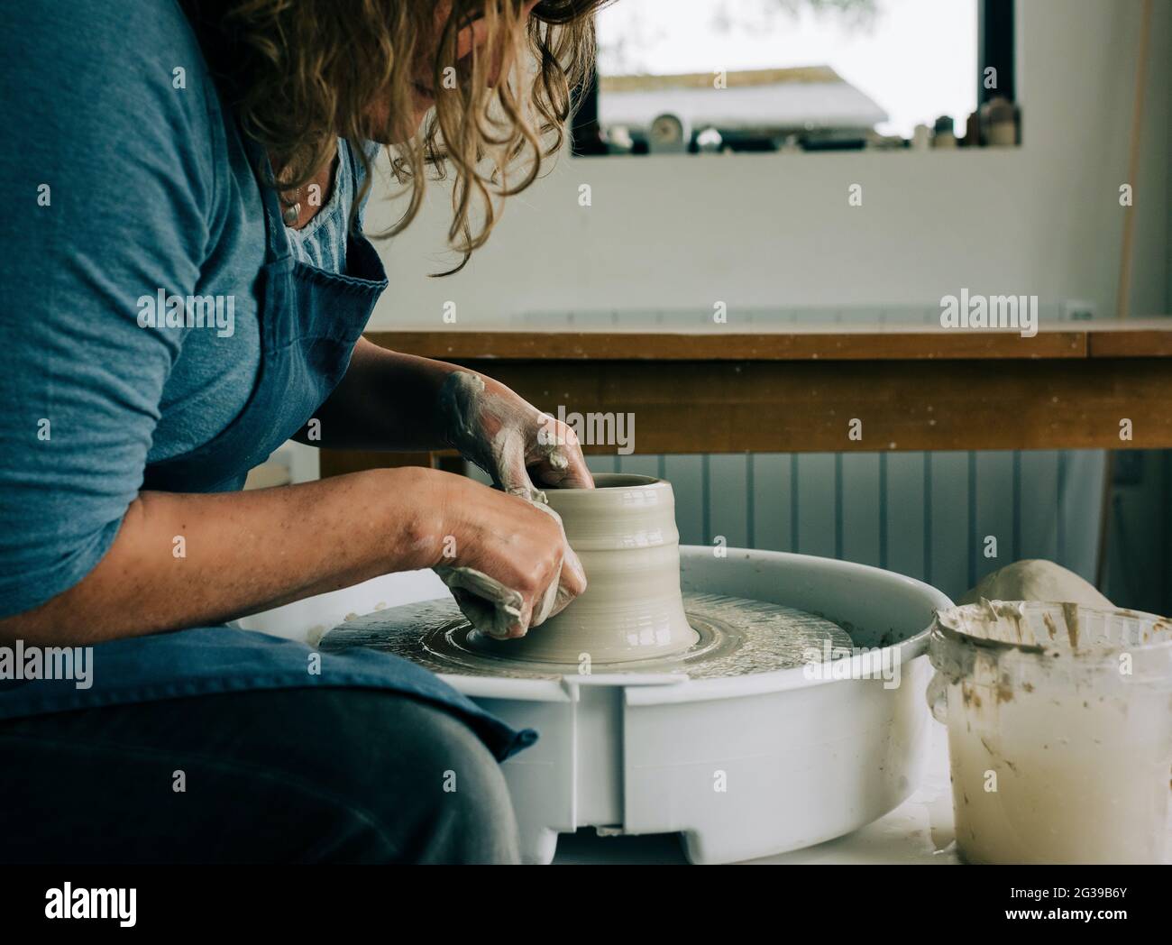 Femme modelage de l'argile sur une roue de poterie dans un studio au Royaume-Uni Banque D'Images