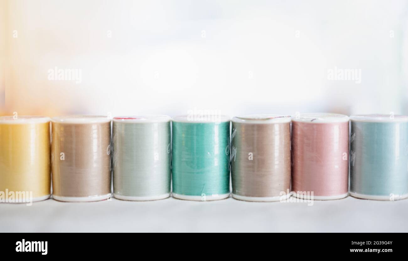 La bobine de fils de broderie de couleur pastel utilisant dans l'industrie  du vêtement, la rangée de rouleaux de fils multicolores, matériel de  couture vendant sur le marché, pour le passe-temps Photo