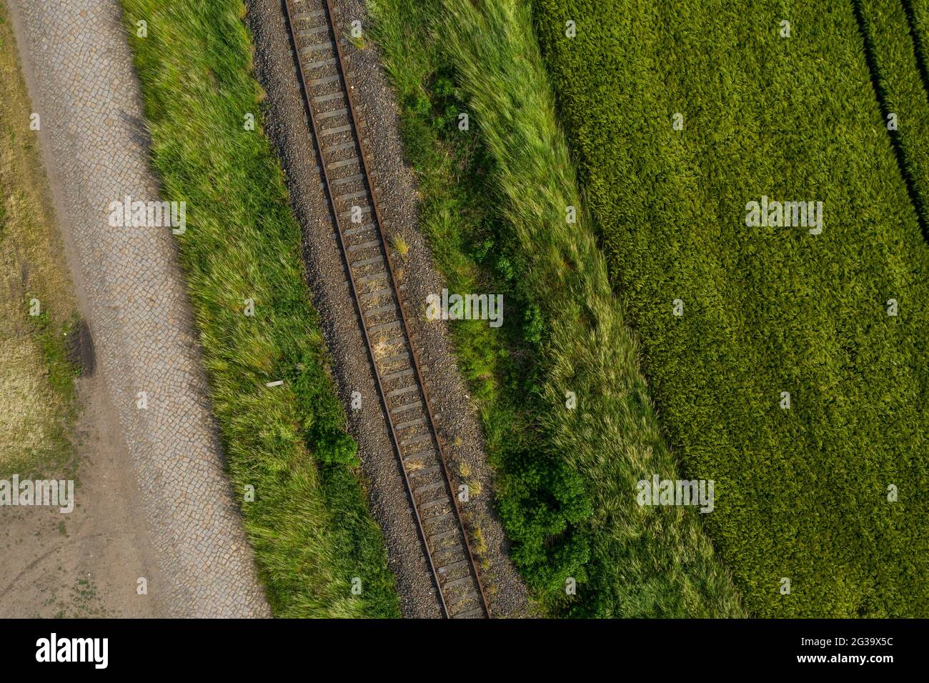 Wanzleben, Allemagne. 13 juin 2021. Une ancienne voie ferrée passe devant des champs fraîchement labourés. (Tourné avec un drone) Credit: Stephan Schulz/dpa-Zentralbild/ZB/dpa/Alay Live News Banque D'Images