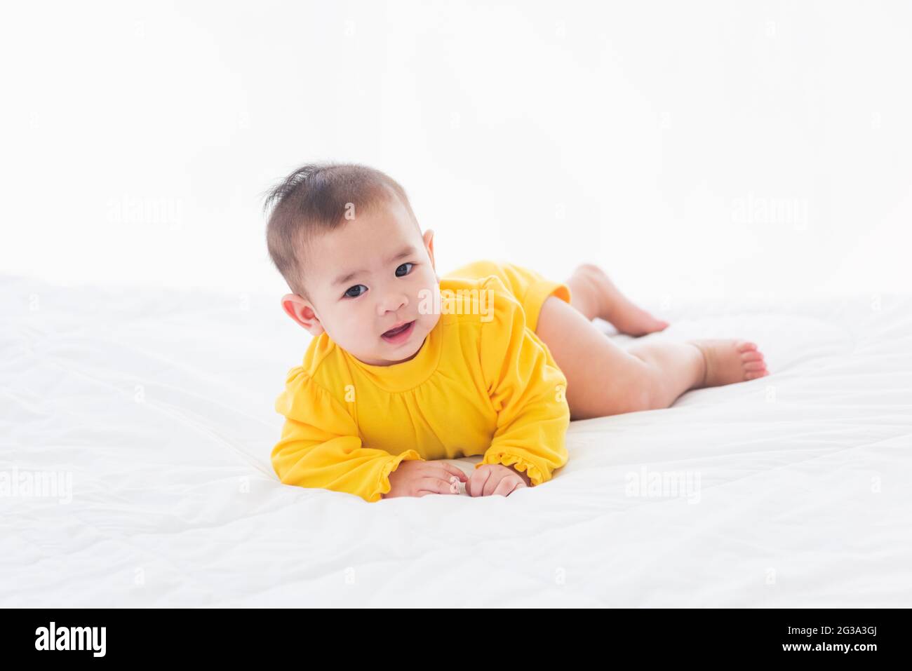 Portrait De Beau Jeune Asiatique Nouveau Ne Petit Bebe Decubitus Ventral Sur Le Lit A La Maison Heureux Bebe Sourire Porte Une Chemise Jaune Relaxant Dans La Chambre Family Mor Photo Stock