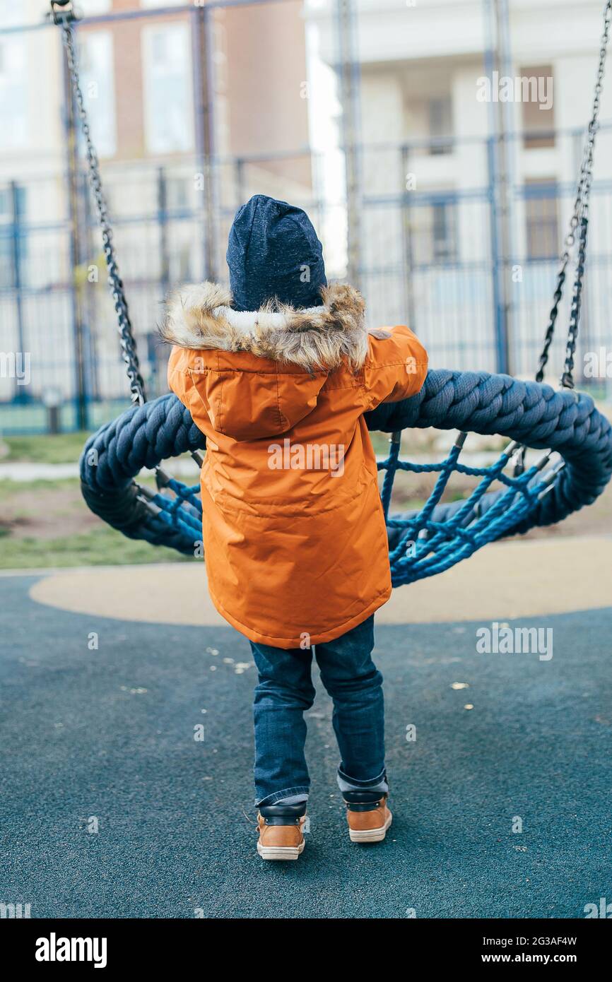 Garçon de 5 ans avec une veste orange sur le terrain de jeu. Activités de  loisirs en plein air pour les enfants, jeux dans la rue Photo Stock - Alamy