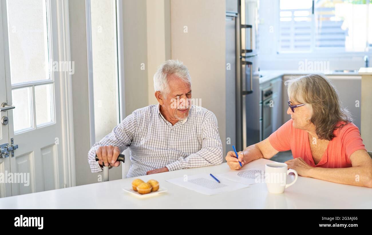 Couple senior retraité résolvant des puzzles comme teasers de cerveau et la formation de mémoire à la maison Banque D'Images