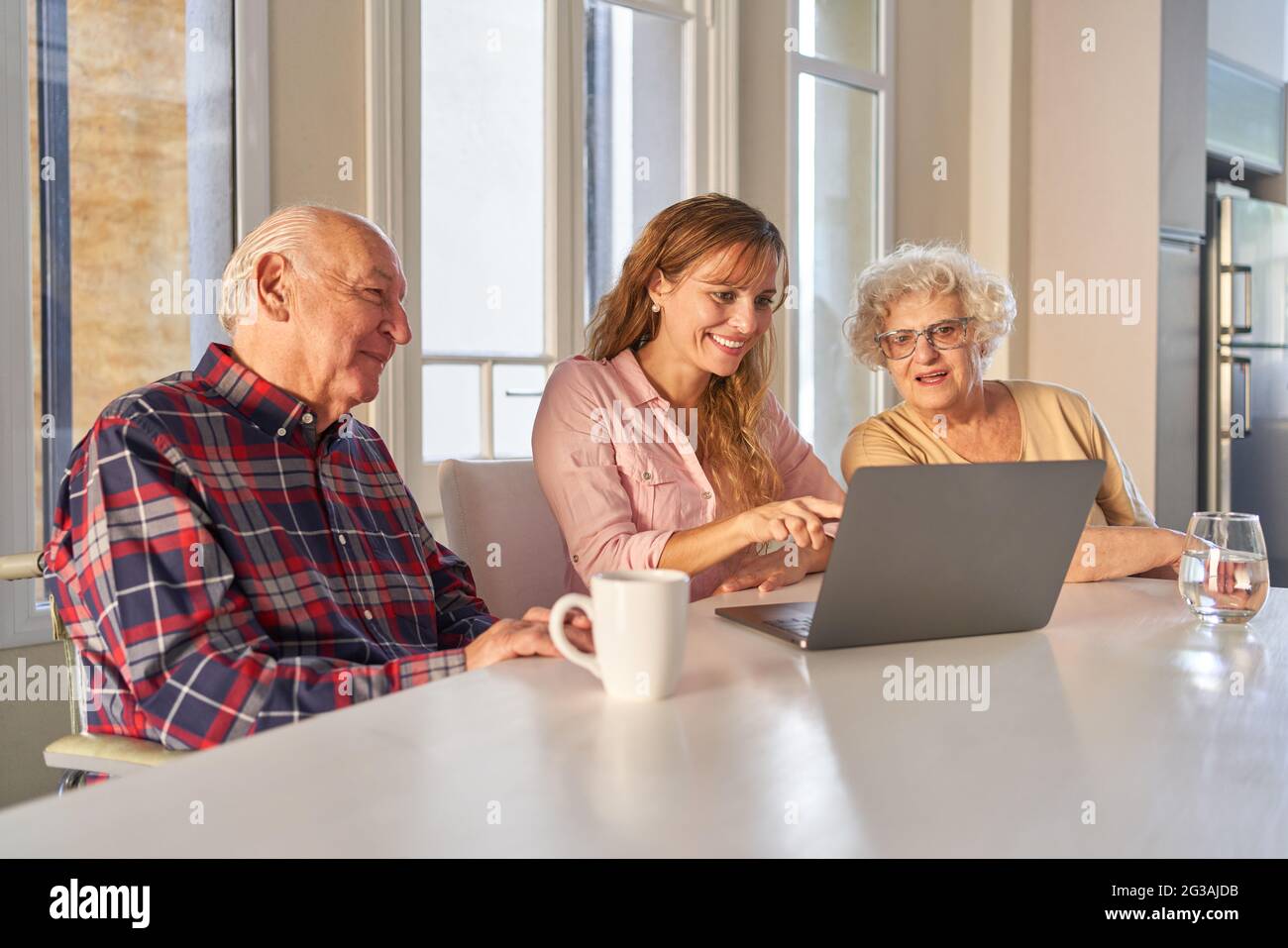 Fille explique aux parents âgés la communication Internet et le chat vidéo sur l'ordinateur portable Banque D'Images