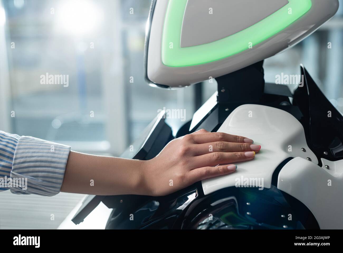 vue rognée de la main femelle touchant le robot dans le bureau Banque D'Images