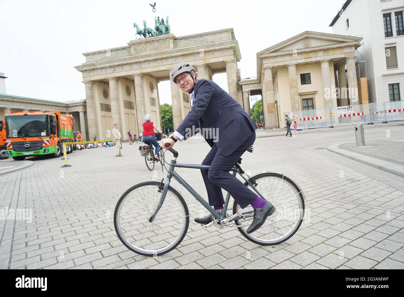 15 juin 2021, Berlin: Andreas Scheuer (CSU), ministre fédéral des Transports, monte à vélo devant la porte de Brandebourg après la remise de deux nouveaux véhicules de collecte de déchets de piles à combustible pour le Berliner Stadtreinigungsbetriebe (BSR). Photo: Jörg Carstensen/dpa Banque D'Images
