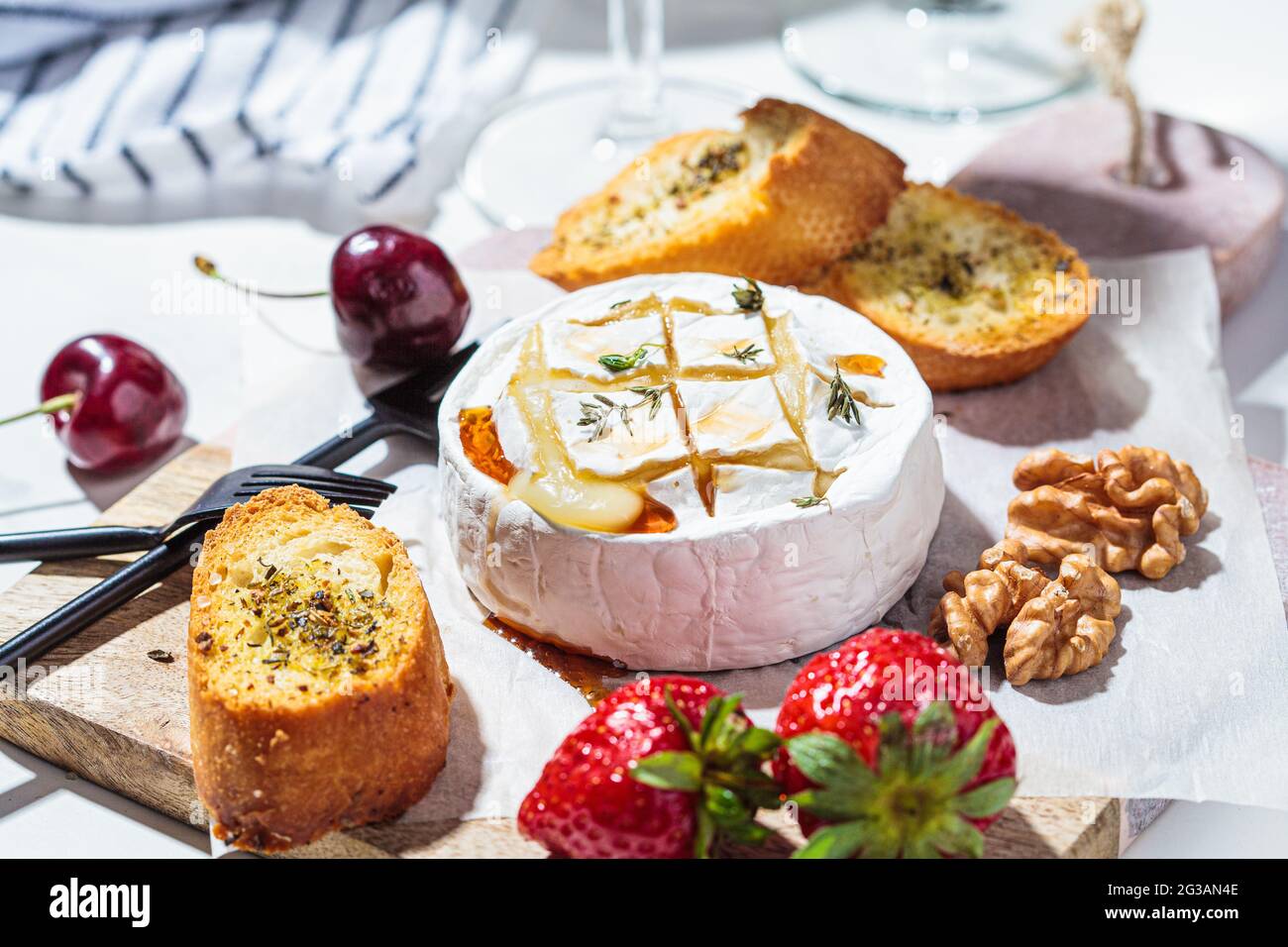 Fromage camembert ou Brie cuit au four avec du thym et du sirop d'érable.  Fromage, fruits, pain et noix au vin blanc Photo Stock - Alamy