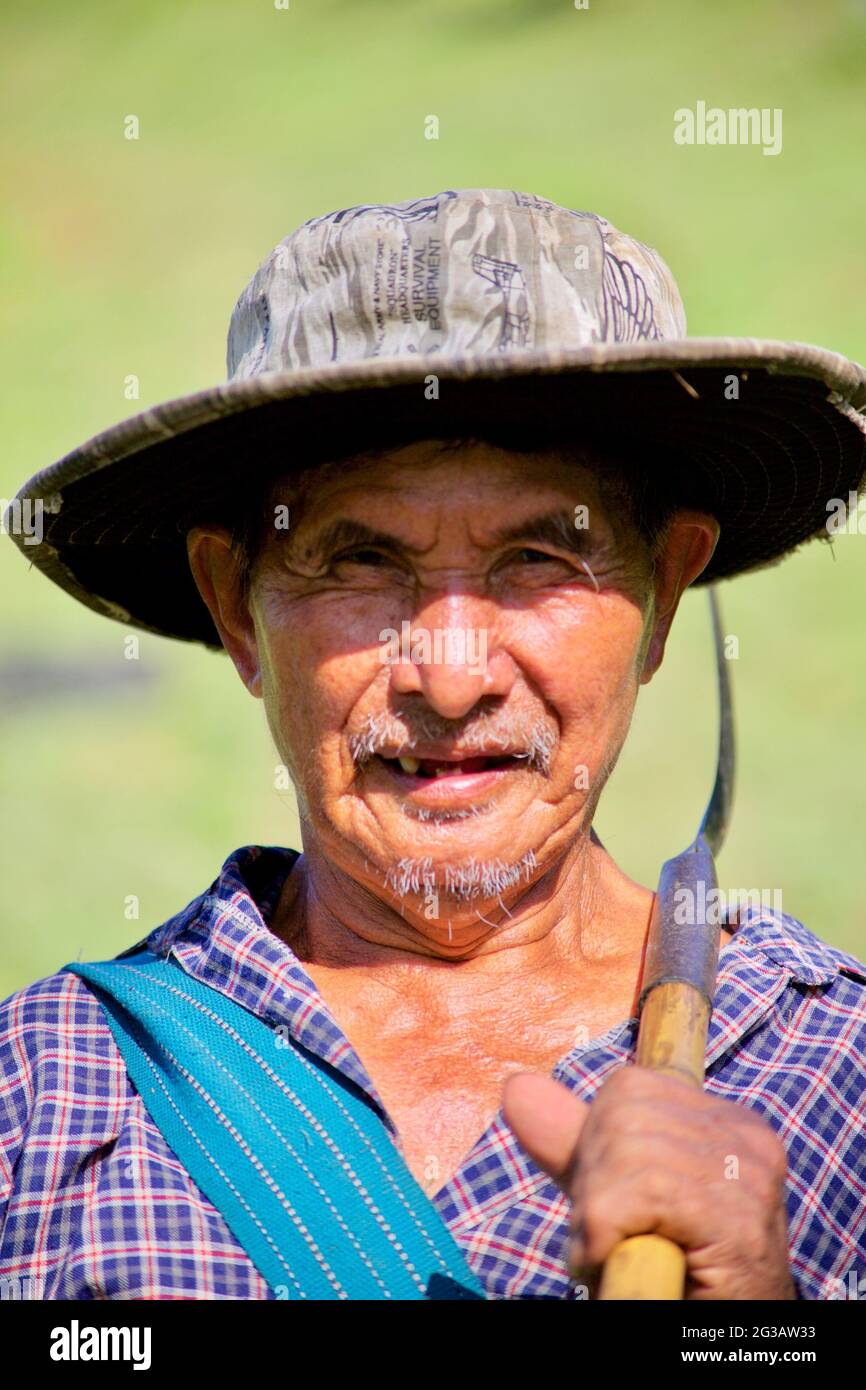 Un fermier de thé pose pour un portrait après une dure journée de travail dans les champs de thé. Banque D'Images