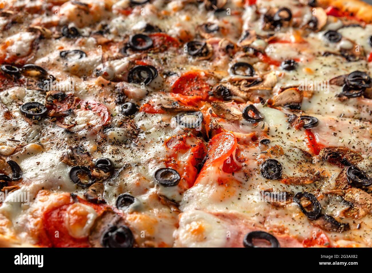 Pizza italienne traditionnelle avec fromage, olives, tomate, oignon, saucisse de pepperoni gros plan Banque D'Images
