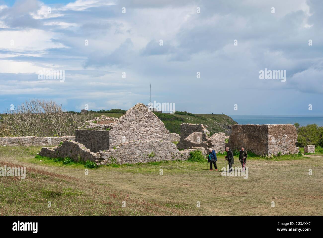 Personnes âgées marchant, vue de trois amis âgés marchant dans les ruines du fort du Sud à Berry Head à Torbay, Devon, Angleterre, Royaume-Uni Banque D'Images