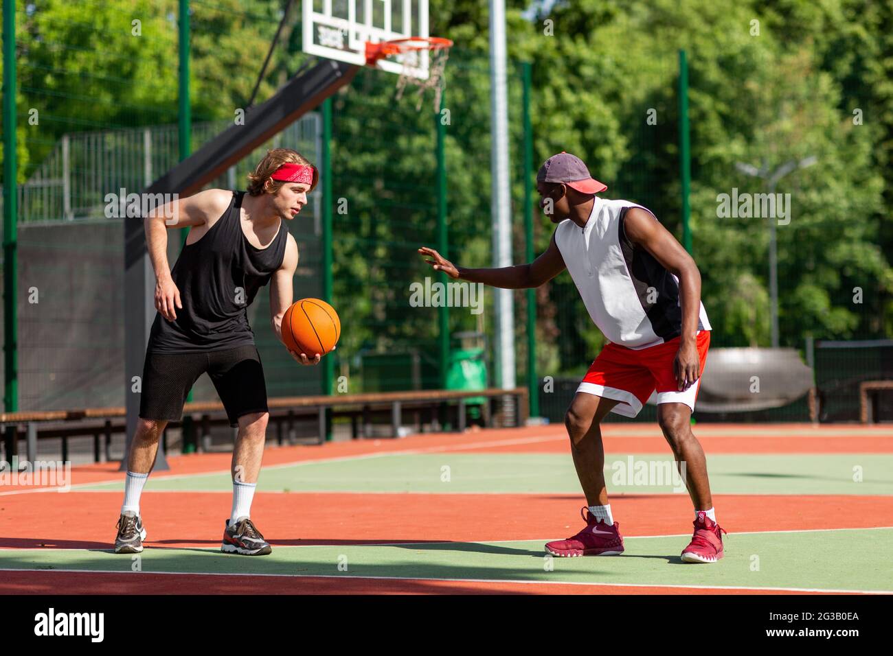 Deux jeunes sportifs jouant au basket-ball au stade par temps chaud. Les  amateurs de basket-ball du millénaire apprécient le jeu amical et se  prépare au tournoi. Extérieur Photo Stock - Alamy
