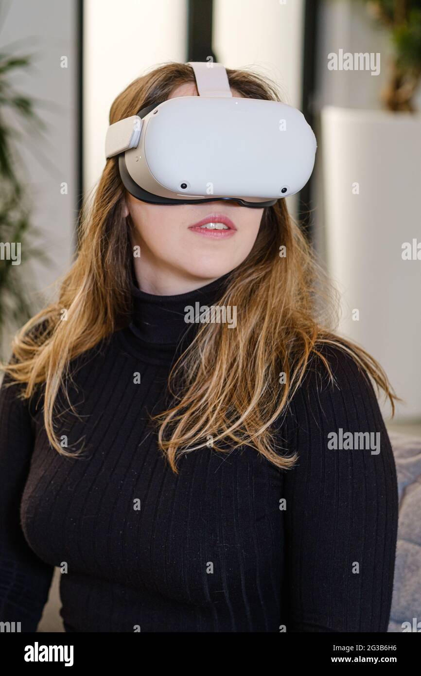 ANVERS, BELGIQUE - 08 avril 2021 : une jeune femme essaie pour la première fois la quête 2 d'Oculus pour une expérience de jeu virtuel. L'air stupéfait. Banque D'Images