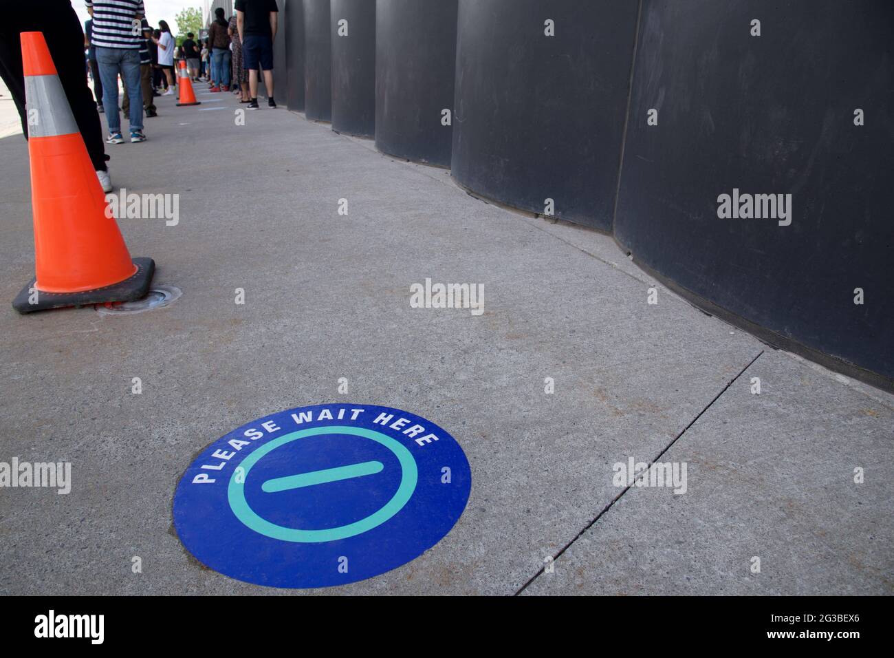Signes de distanciation sociale sur le sol à l'entrée du centre de vaccination. Banque D'Images