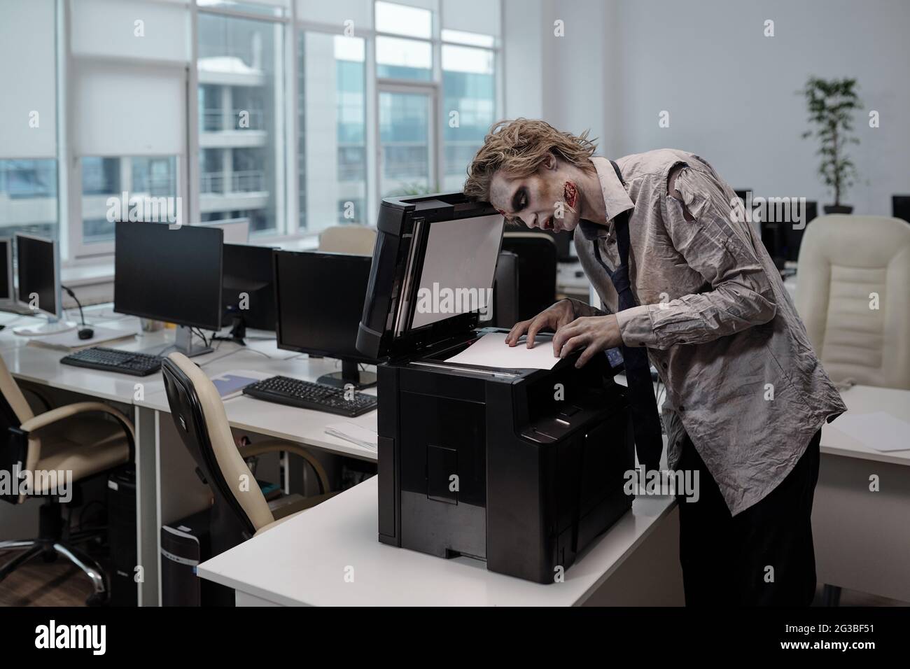 Homme d'affaires zombie debout par xerox et copie de documents dans le bureau Banque D'Images