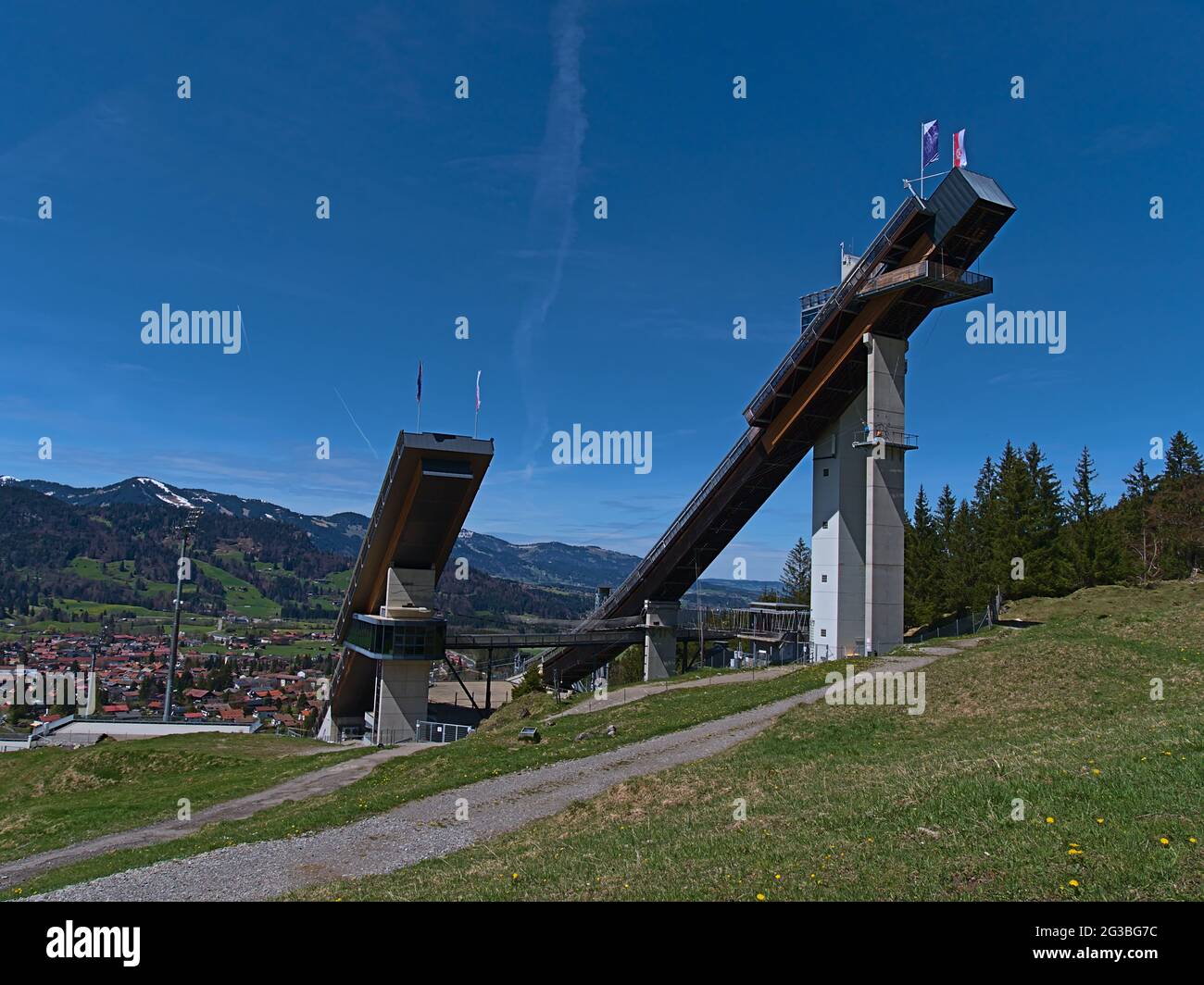Vue sur la colline de saut à ski Audi Arena, qui fait partie du célèbre tournoi de four Hills, le jour ensoleillé au début de l'été avec les montagnes Allgäu. Banque D'Images