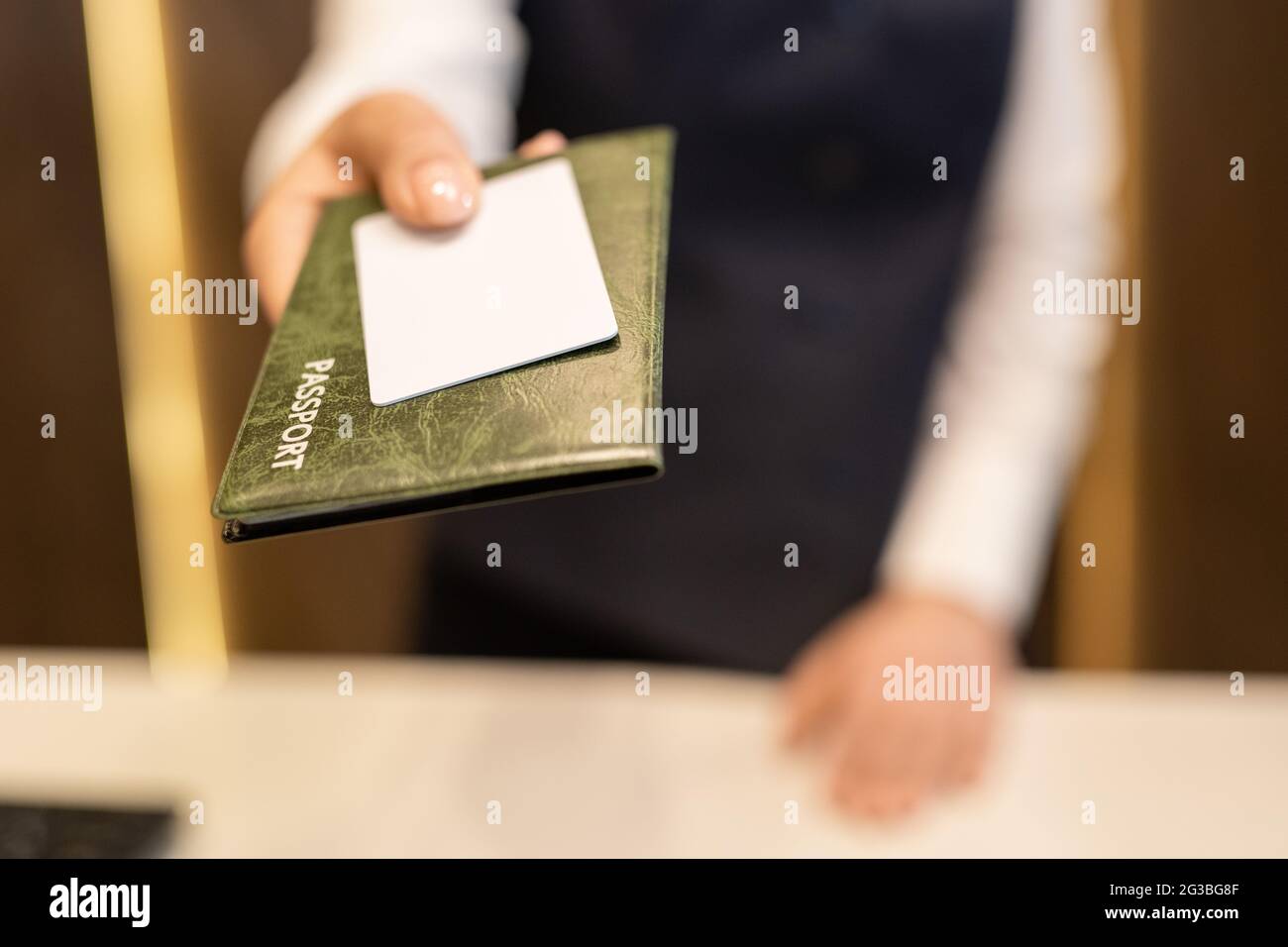 Main de la réceptionniste qui passe le passeport et la carte blanche en plastique vierge Banque D'Images