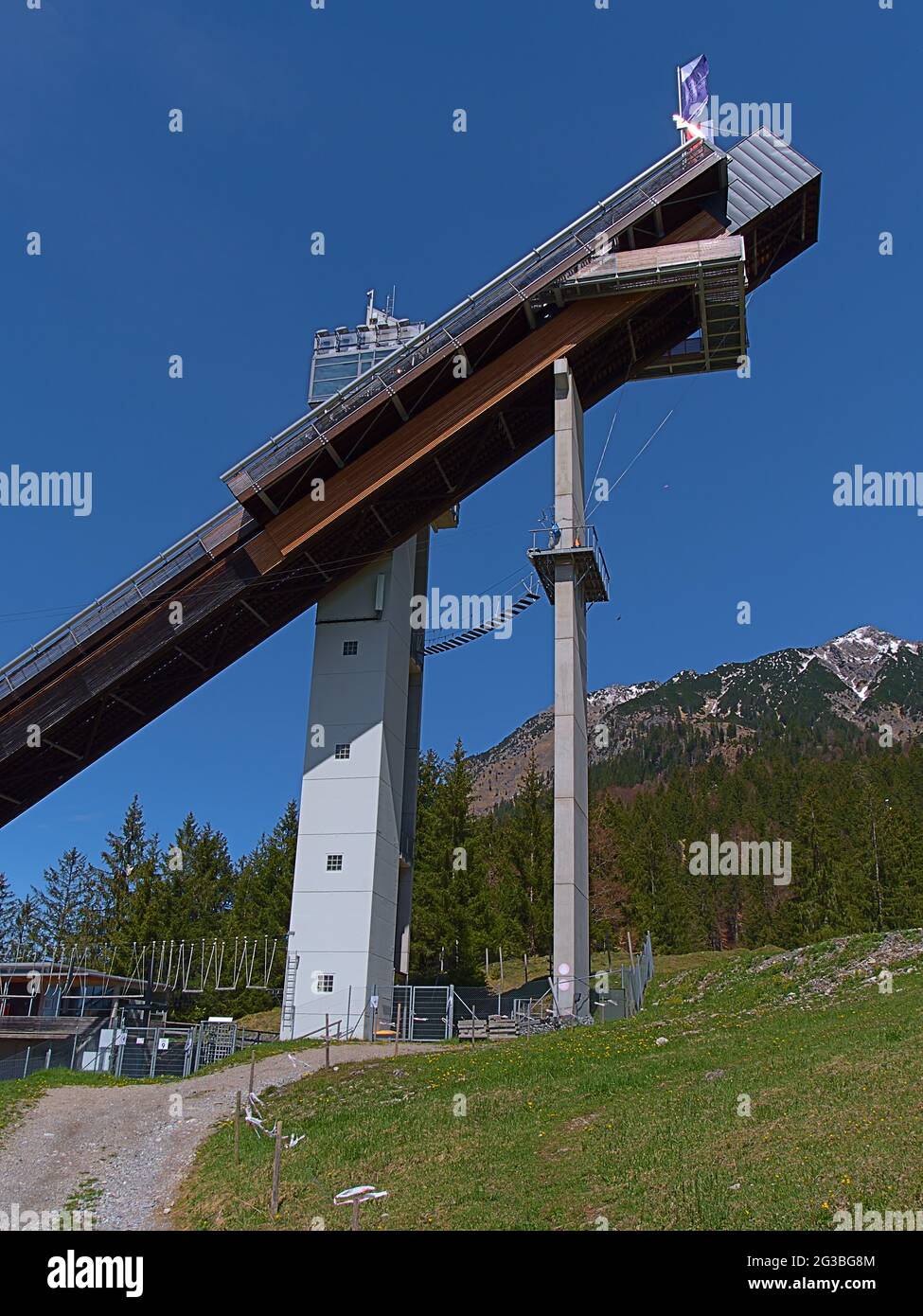 Vue sur la partie supérieure de la colline de saut à ski Audi Arena, qui fait partie du célèbre tournoi de four Hills, le jour ensoleillé en début d'été avec la montagne Allgäu Banque D'Images
