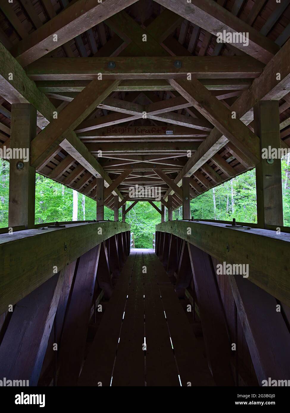 Vue symétrique avec perspective décroissante de l'intérieur d'une passerelle couverte en bois traversant la rivière dans la gorge de Wutach ('Wutachschlucht'). Banque D'Images