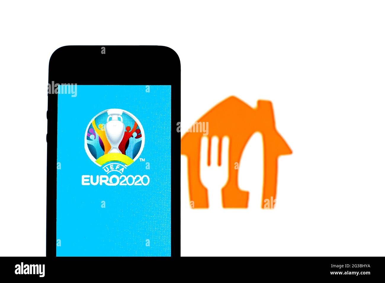 Sur cette photo, un logo UEFA Euro 2020 est affiché sur un smartphone avec un logo Just Eat Takeaway.com en arrière-plan. Banque D'Images