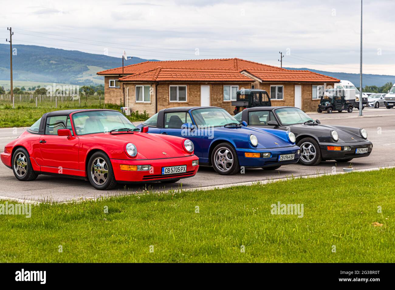Trois Porsche Carreras (rouge, bleu et noir) garées l'une à côté de l'autre Banque D'Images