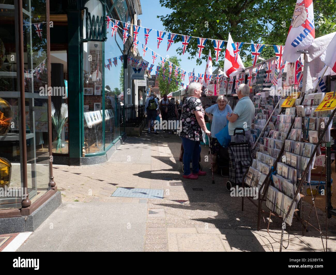 Les gens font du shopping à Epping Market, Epping, Essex, Angleterre, avec les drapeaux Union Jack et Saint George’s Cross affichés. Ambiance traditionnelle de marché de rue britannique. Banque D'Images