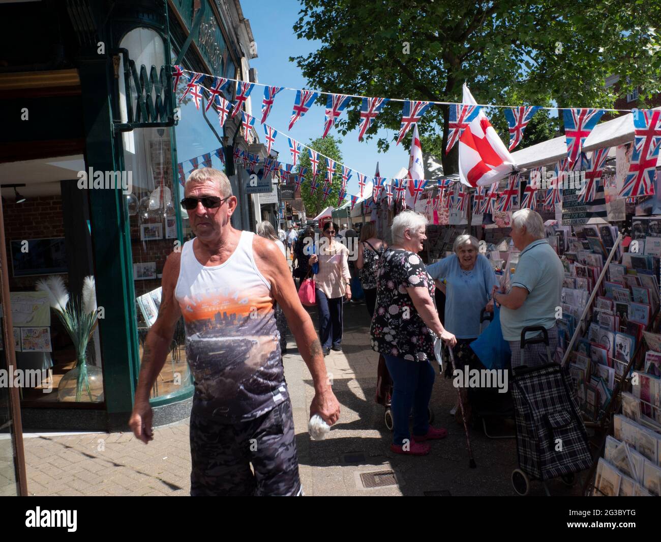 Les gens font du shopping à Epping Market, Epping, Essex, Angleterre, avec les drapeaux Union Jack et Saint George’s Cross affichés. Ambiance traditionnelle de marché de rue britannique. Banque D'Images
