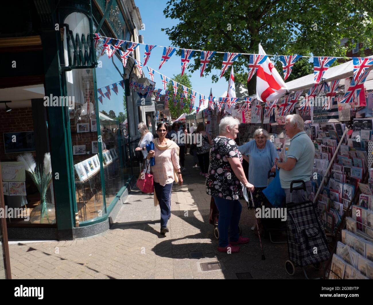 Les gens font du shopping à Epping Market, Epping, Essex, Angleterre, avec les drapeaux Union Jack et Saint George’s Cross affichés. Ambiance traditionnelle de marché de rue britannique. Banque D'Images