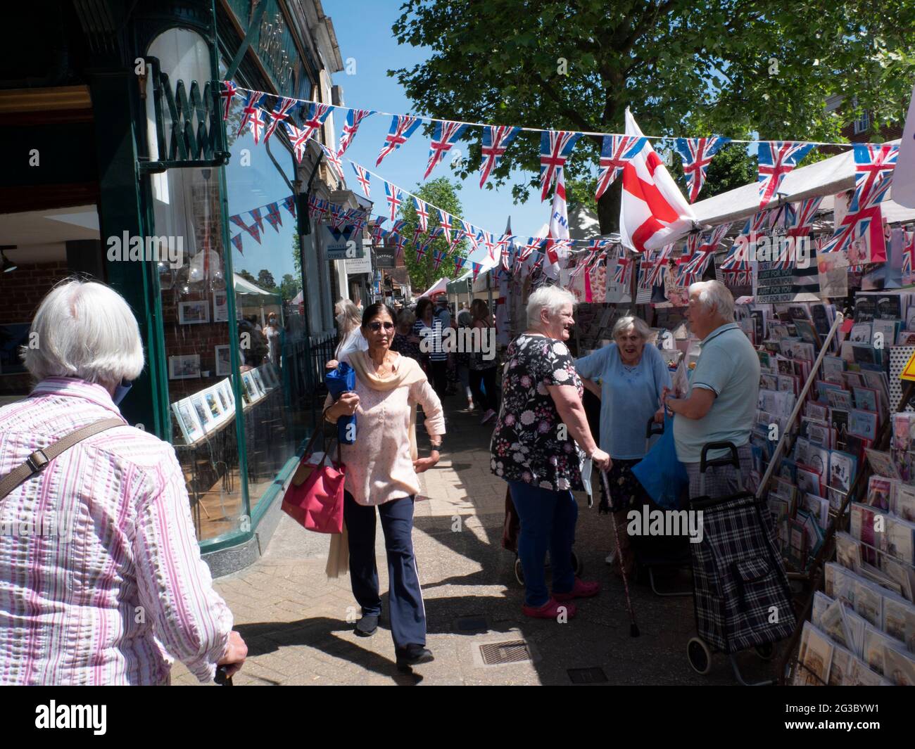 Les gens font du shopping à Epping Market, Epping, Essex, Angleterre, avec les drapeaux Union Jack et Saint George’s Cross affichés. Ambiance traditionnelle de marché de rue britannique. Banque D'Images