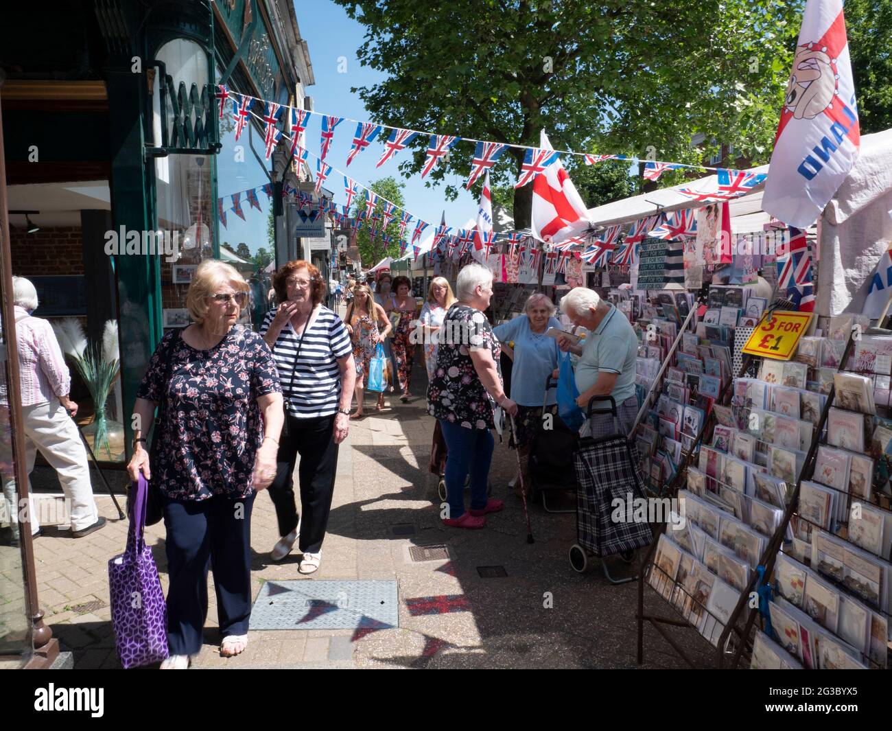 Les gens font du shopping à Epping Market, Epping, Essex, Angleterre, avec les drapeaux Union Jack et Saint George’s Cross affichés. Ambiance traditionnelle de marché de rue britannique. Banque D'Images