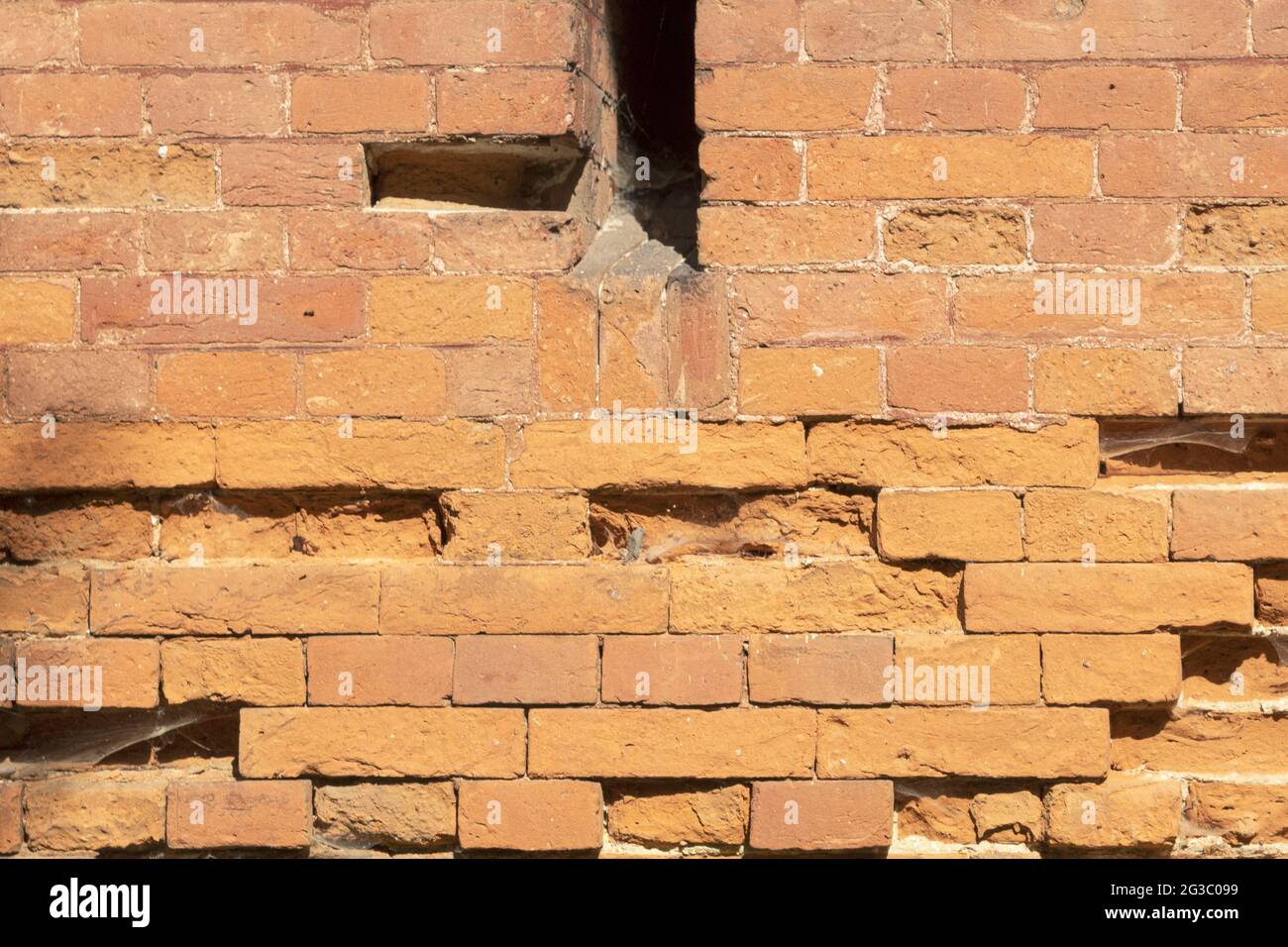 Une échappatoire dans un vieux mur de pierre. Le mur de pierre fortification d'un ancien château avec des échappatoires. Marques de balle et de boule de canon sur le mur. Texturé b Banque D'Images