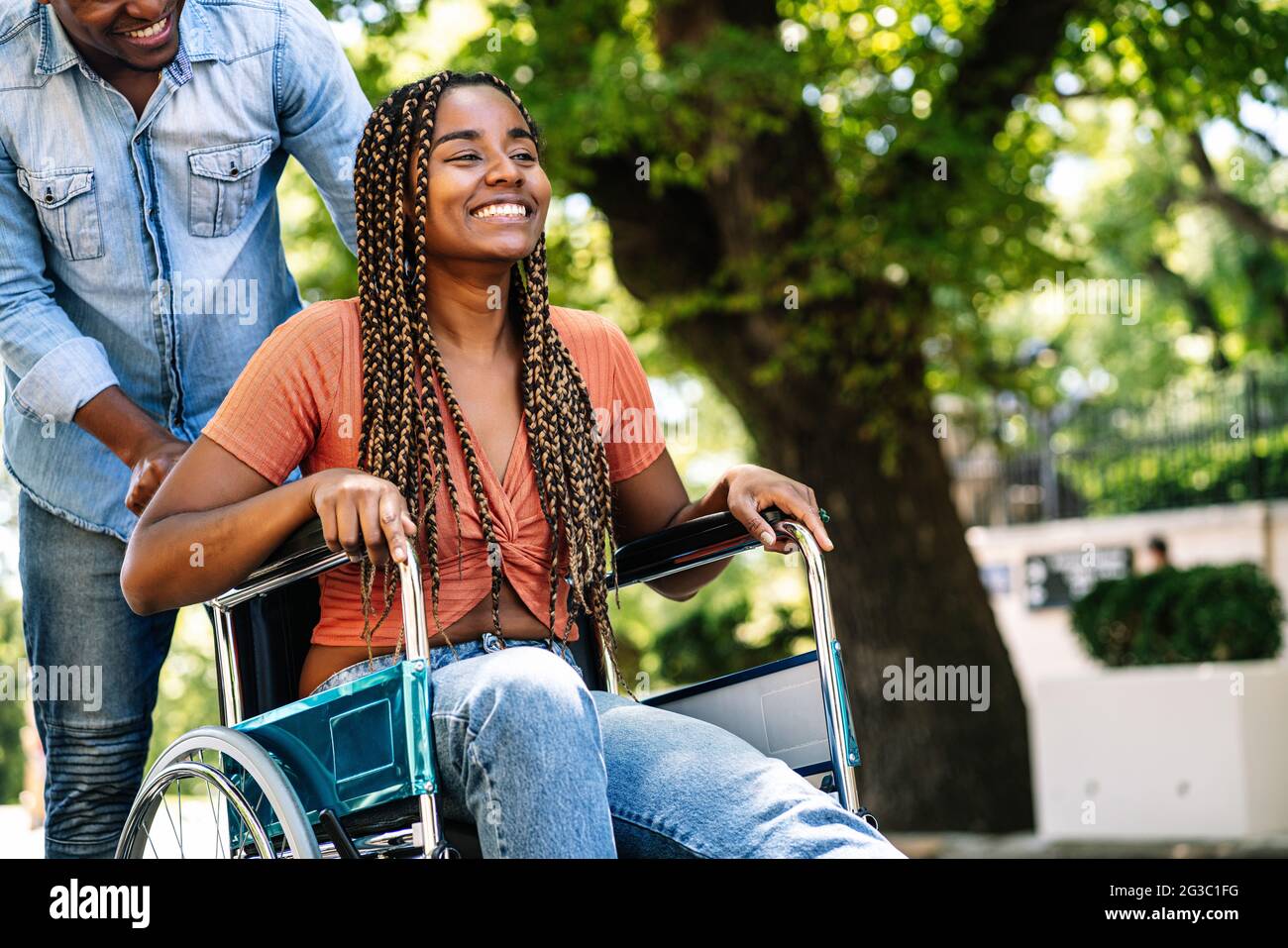 Femme en fauteuil roulant en train de marcher avec son petit ami. Banque D'Images