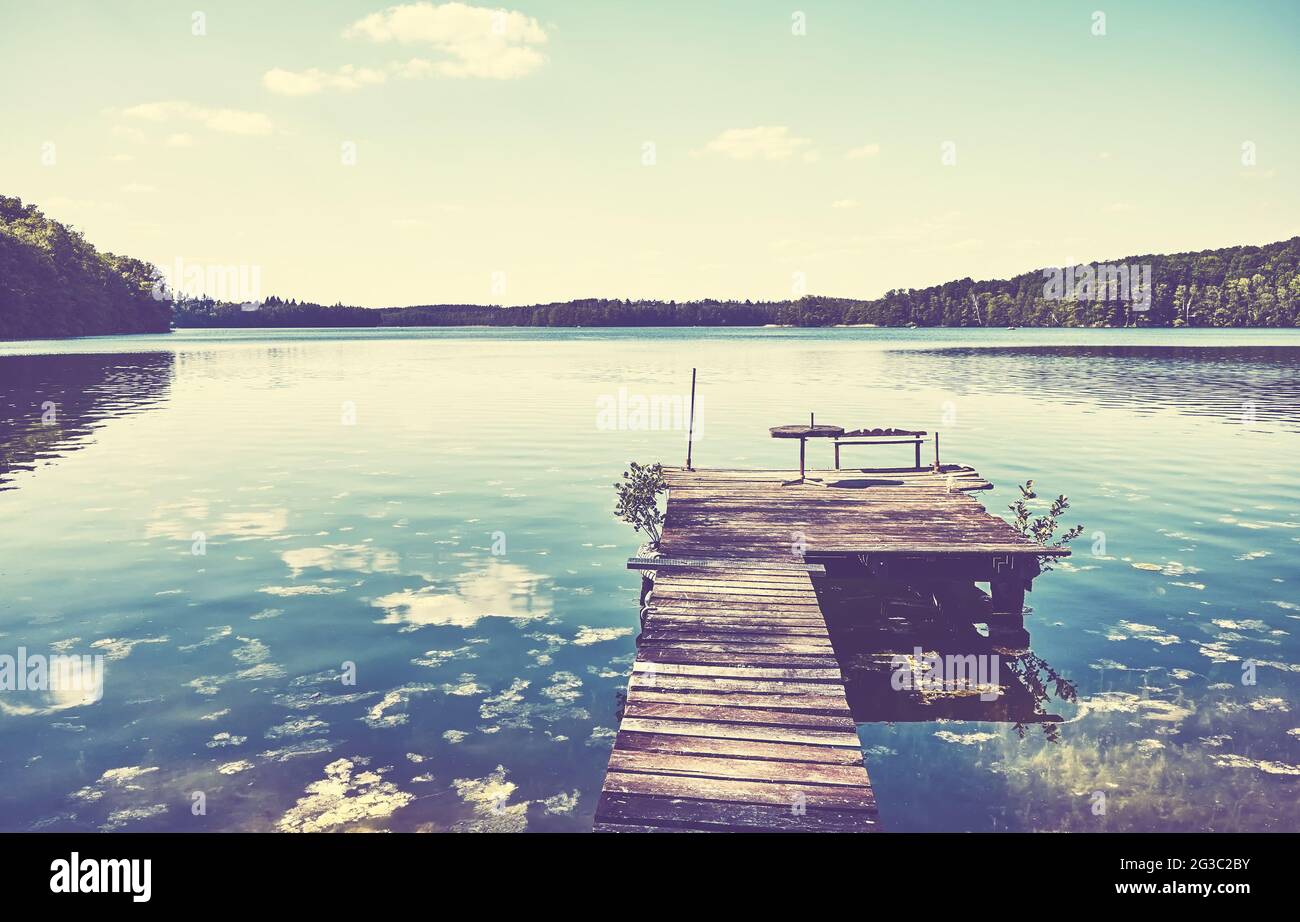Plate-forme en bois au lac Lipie par une journée ensoleillée, couleurs appliquées, Pologne. Banque D'Images