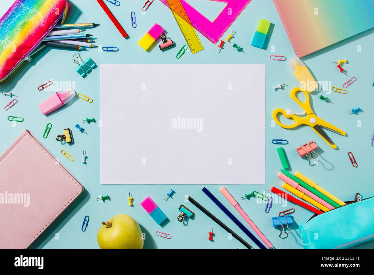 Bureau d'étudiant créatif avec feuille blanche vide et fournitures scolaires modernes colorées sur fond bleu. Vue de dessus. Pose à plat. Copier l'espace. Concept de retour à l'école Banque D'Images
