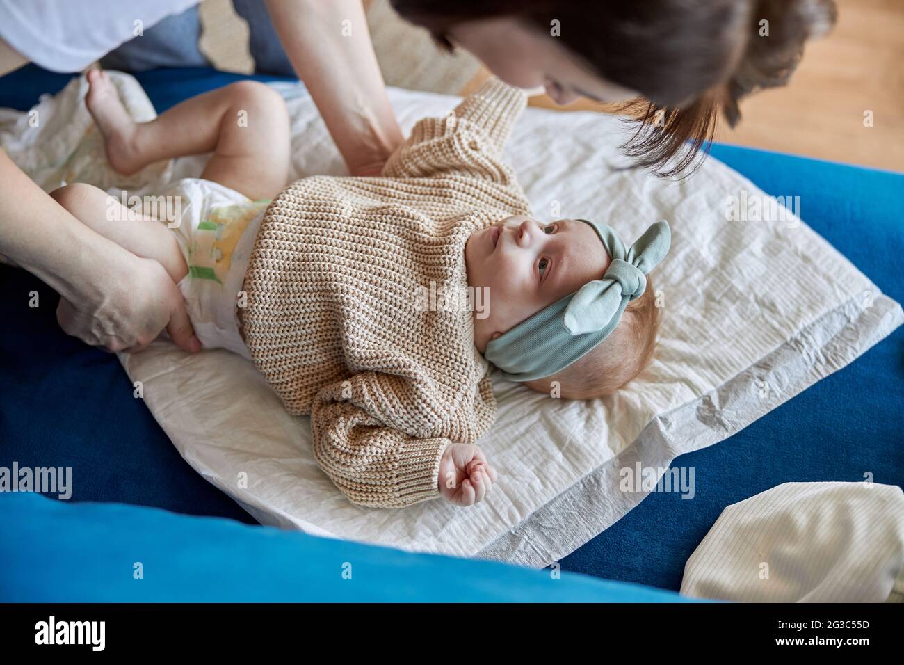 Mere Habille Son Nouveau Ne Bebe Fille Sur Le Canape Photo Stock Alamy