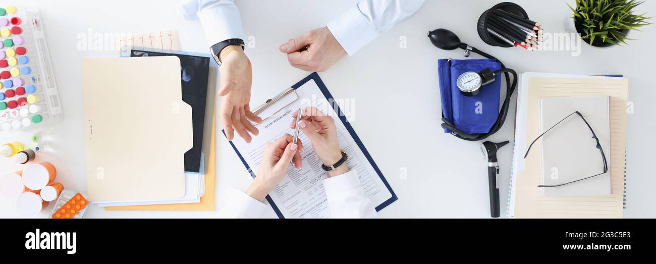 Médecin parlant au patient dans la vue de dessus du bureau Banque D'Images