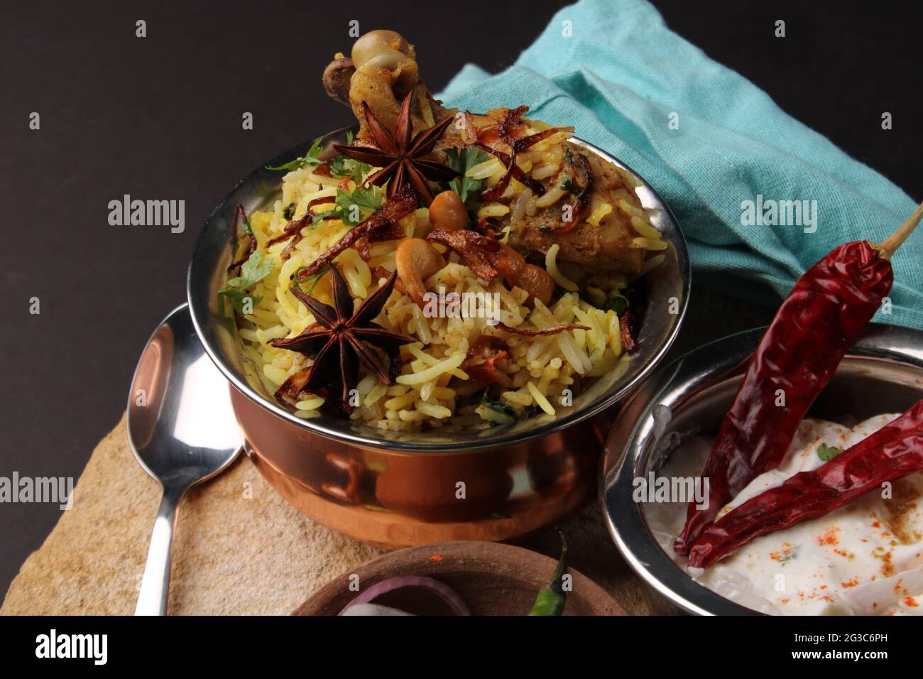 Poulet épicé dum biryani dans un handi traditionnel ou une casserole d'argile. Servi avec raita d'oignon Banque D'Images