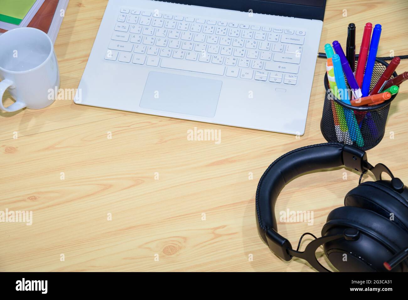 Vue de dessus d'un lieu de travail avec ordinateur portable stylo écouteurs livre et tasse avec espace vide sur le bureau et outils d'apprentissage en ligne, concept stu distant Banque D'Images