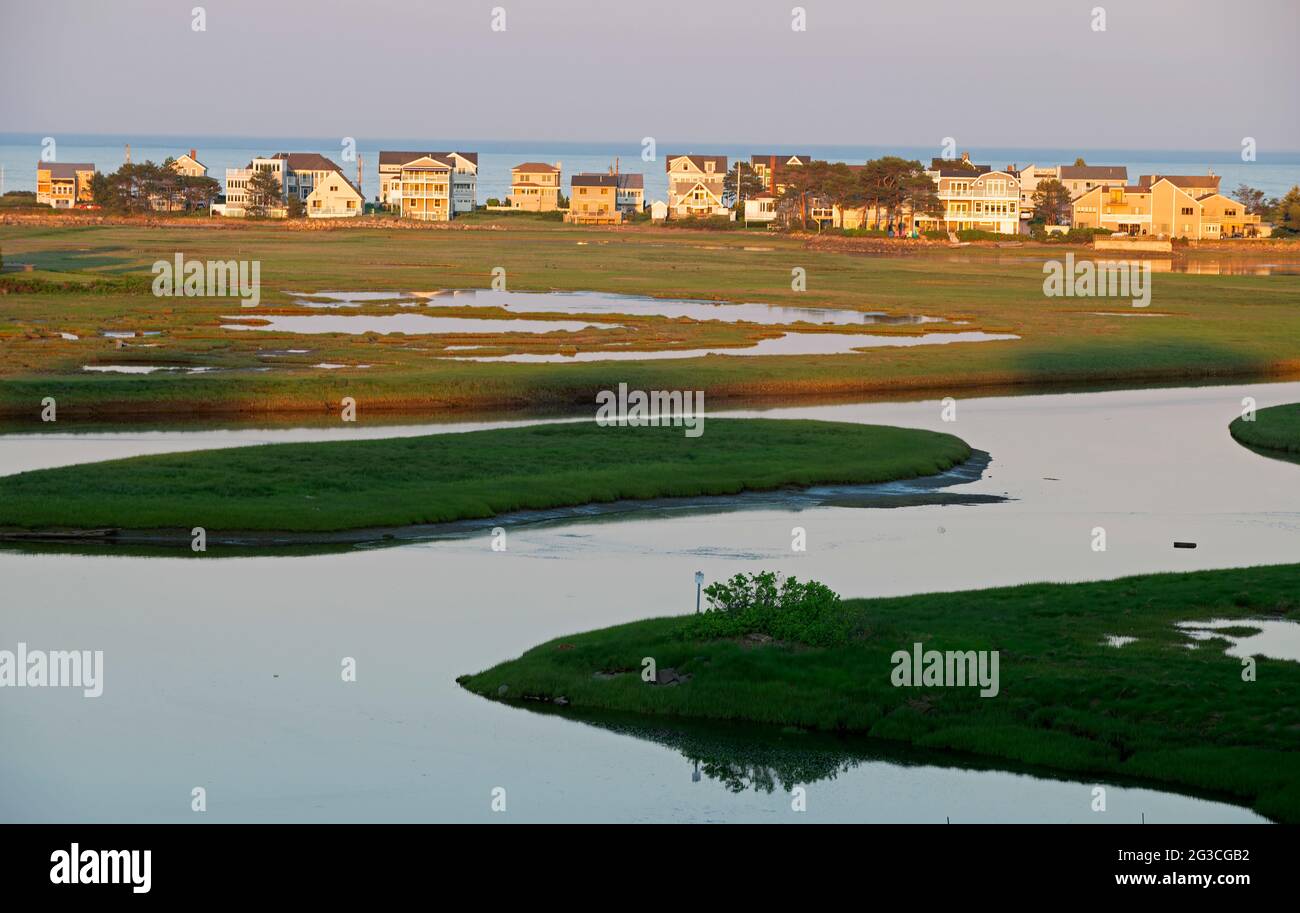 La rivière Ogunquit au coucher du soleil Ogunquit, dans le Maine, en fin d'après-midi de printemps, aux États-Unis. Maisons d'été de Wells, Maine en arrière-plan. Banque D'Images